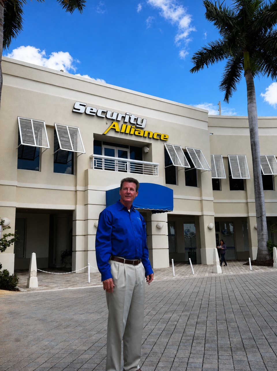 William Murphy standing outside the Security Alliance office building, beneath the company's exterior sign